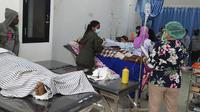Korban banjir menerima perawatan medis di sebuah rumah sakit di Pulau Lembata, provinsi Nusa Tenggara Timur, Minggu (4/5/2021).  Bencana banjir bandang telah menewaskan lebih dari 70 orang dan puluhan hilang serta membuat ribuan orang mengungsi. (AP Photo/Ricko Wawo)
