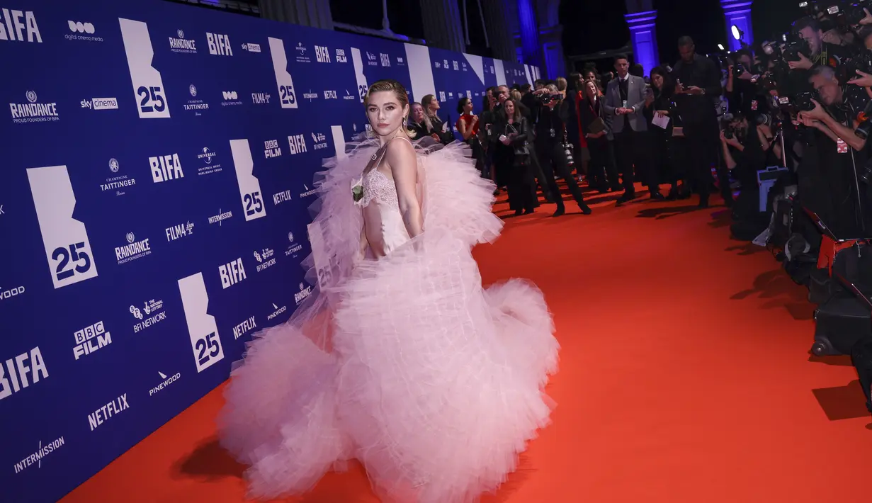 Florence Pugh berpose saat menghadiri British Independent Film Awards ke-25 di London, Inggris pada Minggu, 4 Desember 2022. Dia menambahkan beberapa inci ke tubuhnya yang patut ditiru dengan sepasang sepatu hak bertali dan melengkapi pakaiannya dengan bunga mawar yang lembut. (Photo by Vianney Le Caer/Invision/AP)