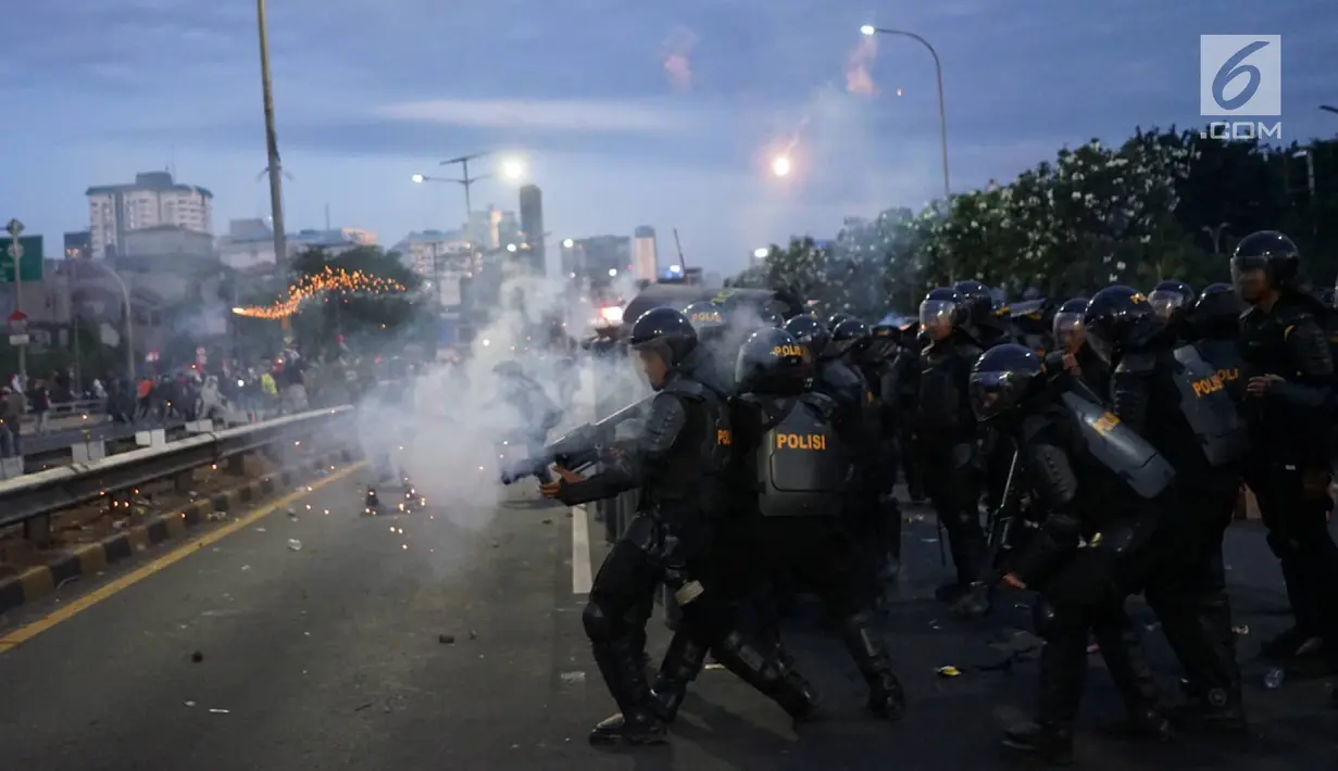 Aparat kepolisian melepaskan tembakan gas air mata untuk membalas serangan petasan yang dilemparkan oleh demonstran di sekitar Gedung DPR RI, Jakarta, Senin (30/9/2019). Demo mahasiswa dan sejumlah elemen tersebut berakhir dengan bentrok dengan polisi. (Liputan6.com/Immanuel Antonius)