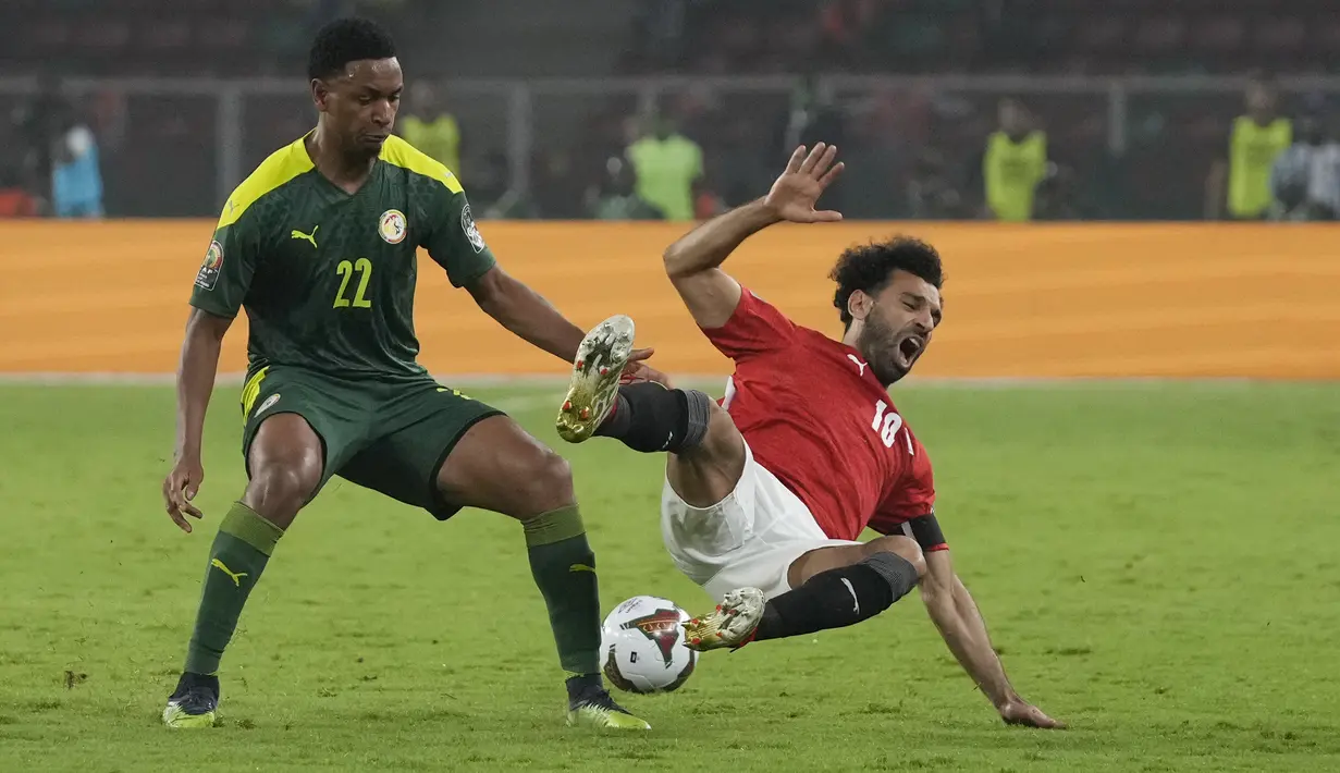 Bek Senegal Fode Ballo-Toure menjegal penyerang Mesir Mohamed Salah pada pertandingan final Piala Afrika 2021 di Paul Biya Stadium, Kamerun, Senin (7/2/2022) dini hari WIB. Sadio Mane membawa Senegal mengalahkan Mesir lewat adu penalti dengan skor 4-2. (AP Photo/Themba Hadebe)