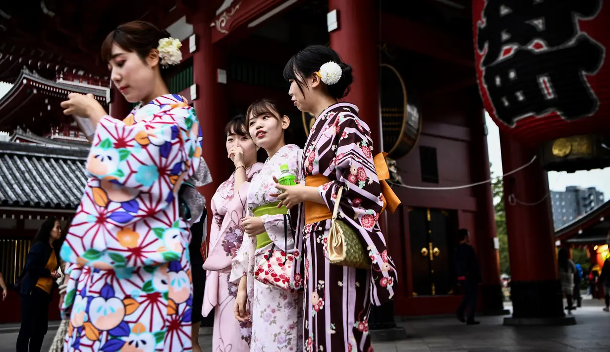 Gambar pada 21 Oktober 2019 menunjukkan sejumlah perempuan mengenakan pakaian tradisional Jepang, kimono, saat mengunjungi kuil Senso-ji di Tokyo. Sensoji Temple merupakan salah satu kuil tertua di Jepang yang terletak di Asakusa. (Anne-Christine POUJOULAT / AFP)