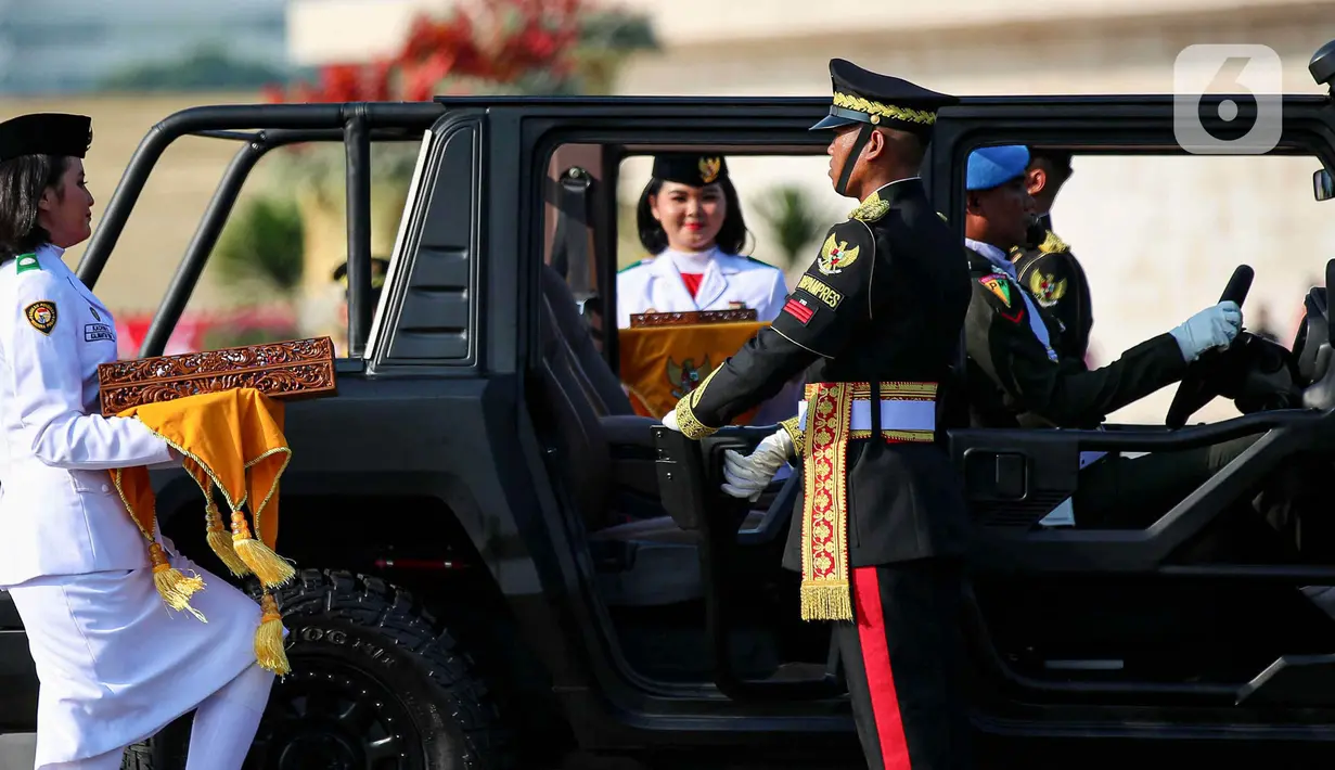 <p>Personel Purna Paskibraka 2023 bersiap menaiki mobil Maung Pindad sambal me,bawa replica Merah Putih dan teks proklamasi prosesi kirab dari Kawasan Monas menuju Lanud Halim Perdanakusuma, Jakarta, Sabtu (10/8/2024). (Liputan6.com/Herman Zakharia)</p>