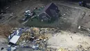 Rumah dan mobil yang rusak terlihat di Waverly, Tennessee, Rabu (25/8/2021). Hujan deras selama akhir pekan menyebabkan banjir di Tennessee Tengah dan telah mengakibatkan puluhan orang tewas karena rumah dan jalan pedesaan hanyut. (AP Photo/Mark Humphrey)