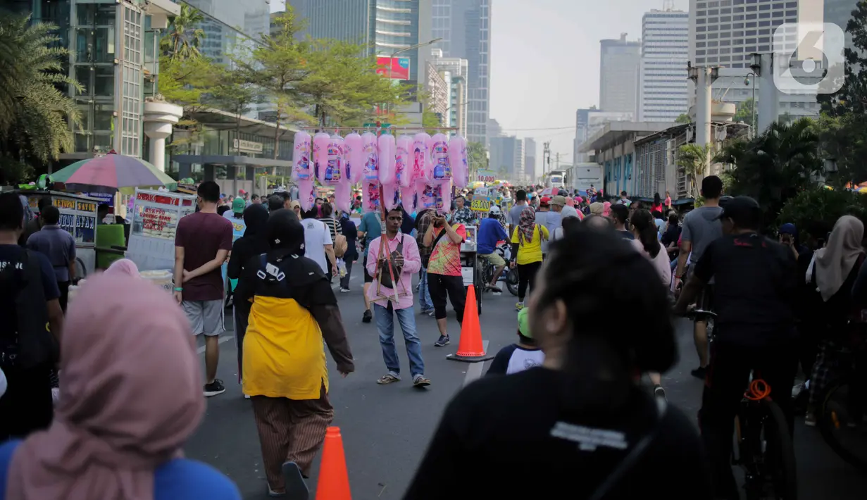 Pedagang kaki lima (PKL) berjualan di jalan saat car free day (CFD) di kawasan Bundaran HI, Jakarta, Minggu (6/10/2019). Banyaknya PKL nakal yang berjualan tidak pada tempatnya menyebabkan olahraga warga terganggu. (Liputan6.com/Faizal Fanani)