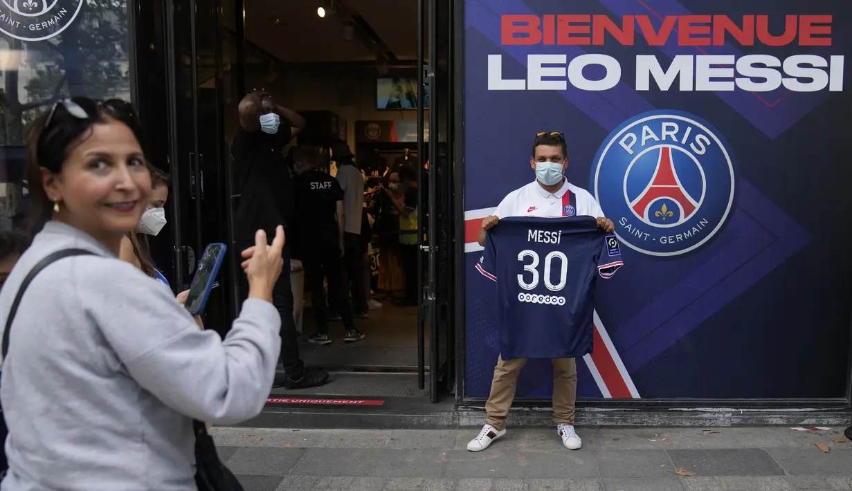 Seorang suporter Paris Saint-Germain menunjukkan jersey bertuliskan nama Lionel Messi yang baru dibelinya, di luar toko resmi PSG di Paris, Rabu (11/8/2021). Penjualan jersey PSG dengan nama Messi dan nomor punggung 30 laris manis, bahkan fans rela antre panjang. (AP Photo/Francois Mori)