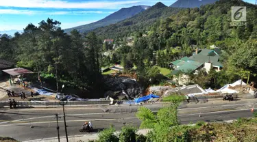 Pengendara motor melintasi kawasan longsor di Desa Ciloto, Kabupaten Cianjur, Jawa Barat, Kamis (29/3). Longsor di bahu Jalan Raya Puncak itu membuat arus lalu lintas ditutup sementara bagi pengendara roda empat. (Merdeka.com/Arie Basuki)