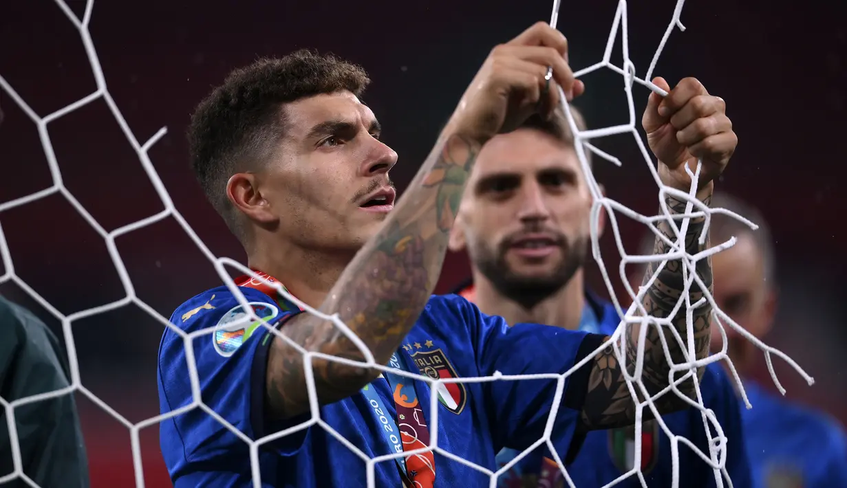Tak ketinggalan, aksi itu juga dilakukan oleh Giovanni Di Lorenzo. Ia tampak sedang memilih bagian mana yang akan dipotong. (Foto: AP/Pool/Laurence Griffiths)