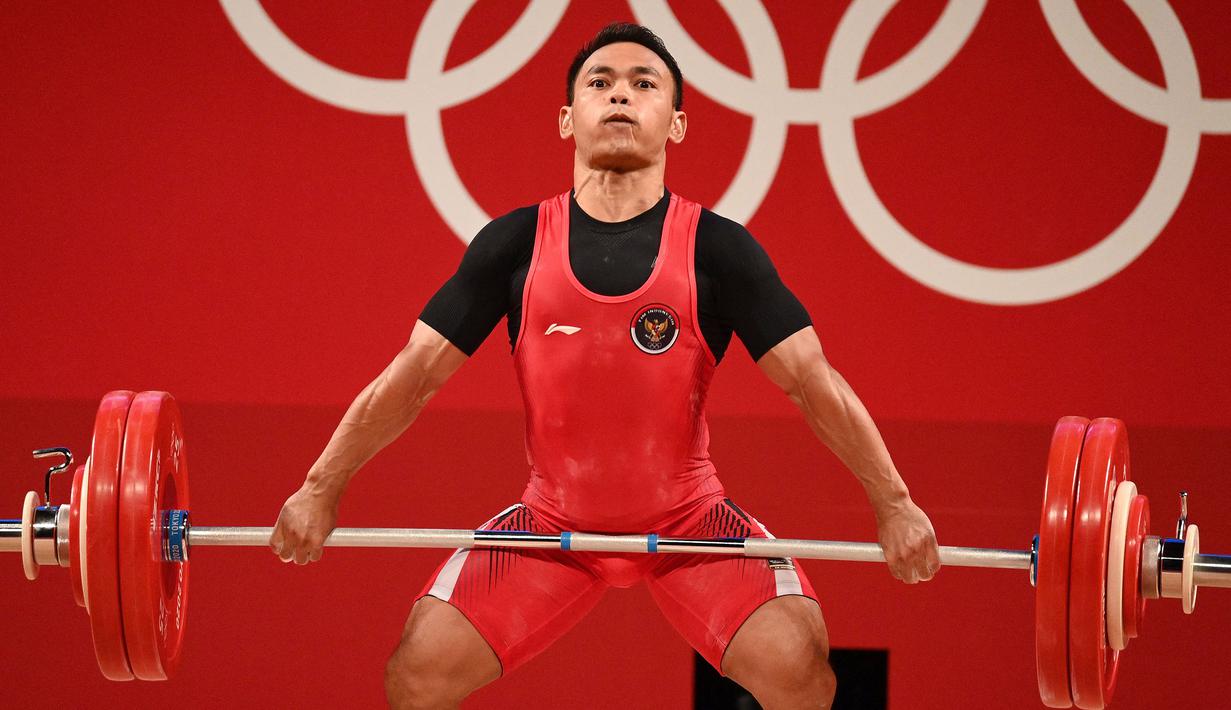 Berhasil memimpin perolehan sementara, Eko sukses pada angkatan snatch pertama. Dirinya berhasil mengangkat 137 kg. (Foto: AFP/Vincenzo Pinto)