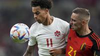 Penyerang Kanada, Tajon Buchanan berebut bola dengan pemain Belgia, Timothy Castagne pada pertandingan grup F Piala Dunia 2022 Qatar di Stadion Ahmad Bin Ali di Doha, Qatar, Kamis (24/11/2022). Belgia menang tipis atas Kanada 1-0.  (AP Photo/Natacha Pisarenko)
