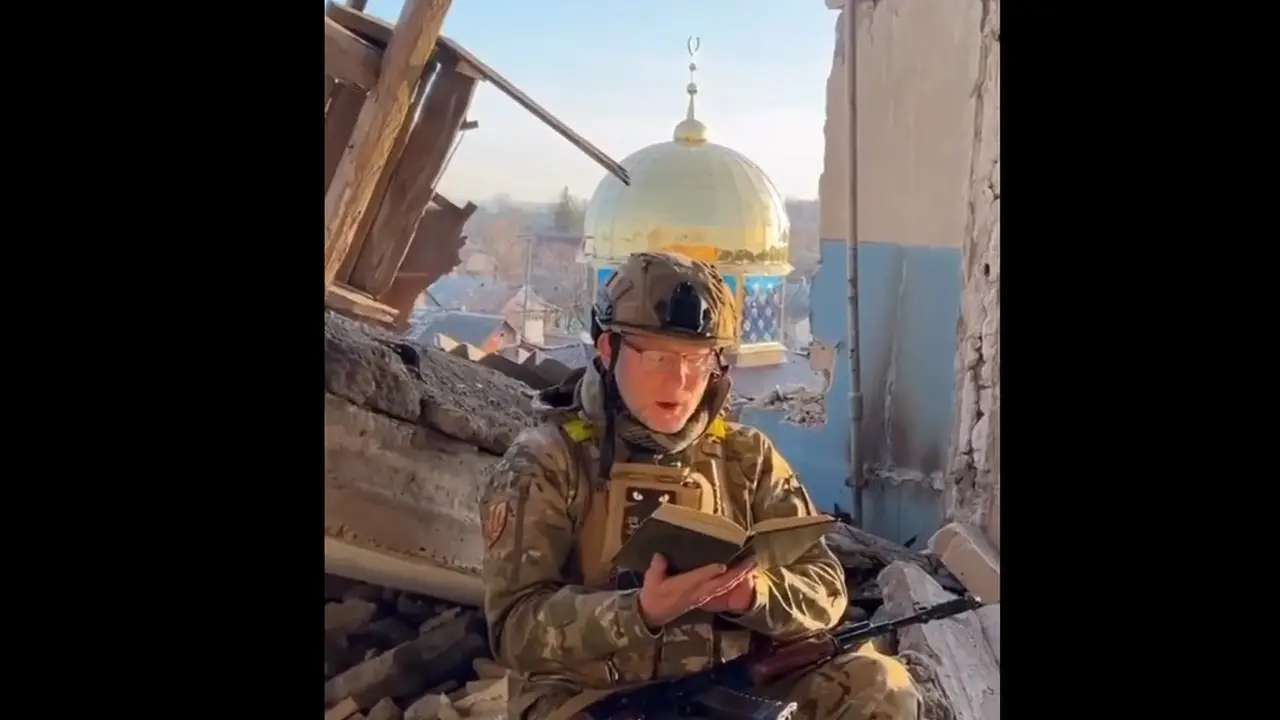 Seorang tentara Ukraina membaca Al-Quran dekat masjid Ukraina yang kena serangan Rusia.