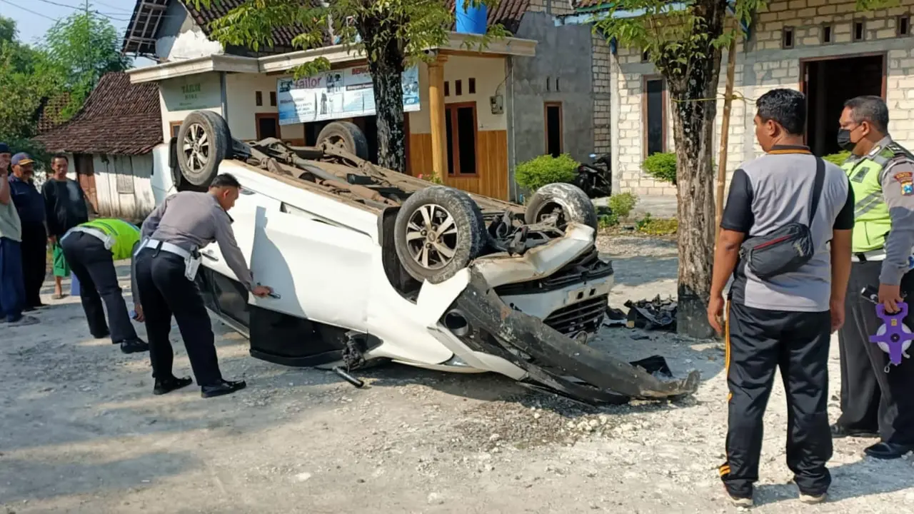 Kondisi mobil Xenia terbalik dan anggota Satlantas Polres Tuban ketika olah tempat kejadian perkara. (Ahmad Adirin/Liputan6.com)