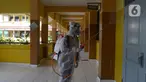 Petugas PMI menyemprotkan cairan disinfektan di Lingkungan SMP Negeri 139 Jakarta, Selasa (9/6/2020). Penyemprotan untuk mencegah penyebaran virus Corona di lingkungan sekolah itu sebagai persiapan memasuki tahun ajaran baru 2020/2021. (merdeka.com/Imam Buhori)