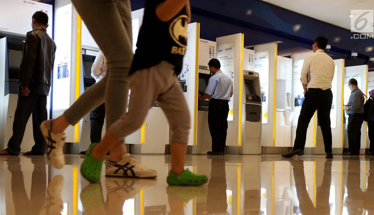 Nasabah melakukan transaksi melalui mesin anjungan tunai mandiri (ATM) di Jakarta Mandiri, Jakarta, Selasa (6/6). Jumlah tersebut meningkat sekitar 10 persen dibandingkan kebutuhan uang tunai harian pada bulan-bulan biasanya. (Liputan6.com/Angga Yuniar)