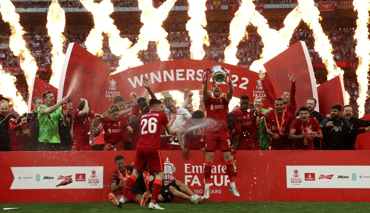 <p>Gelandang Liverpool Jordan Henderson mengangkat trofi Piala FA 2021/2022 dan berselebrasi setelah menang atas Chelsea paad partai final di Stadion Wembley pada Minggu (16/5/2022) dini hari WIB. Liverpool sukses menjuarai Piala FA 2021/2022 mengalahkan Chelsea lewat adu penalti 6-5. (AP Photo/Ian Walton)</p>