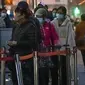 Seorang pekerja yang mengenakan pakaian pelindung berjalan melewati orang-orang yang mengantri untuk tes COVID-19 di tempat pengujian virus corona di Beijing, Rabu (9/11/2022). Lonjakan kasus COVID-19 telah mendorong penguncian di pusat manufaktur China selatan Guangzhou, menambah keuangan tekanan yang telah mengganggu rantai pasokan global dan secara tajam memperlambat pertumbuhan ekonomi terbesar kedua di dunia itu. (Foto AP/Mark Schiefelbein)