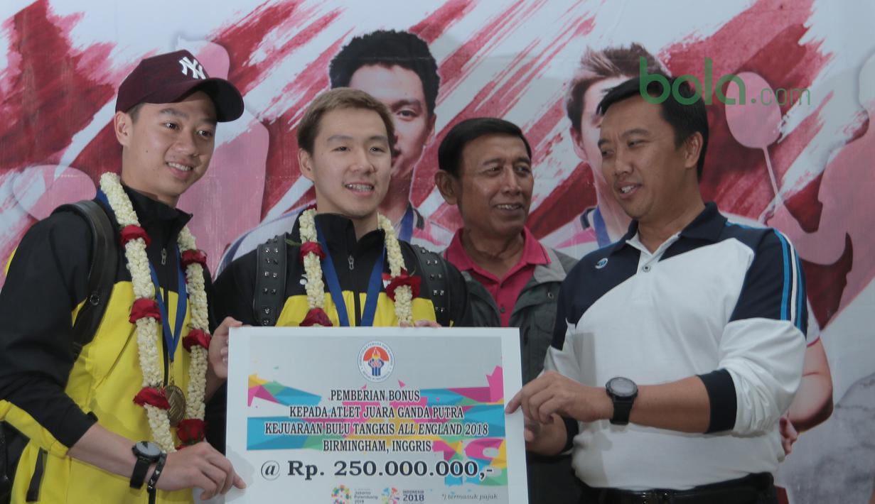 Kevin Sanjaya/Marcus Gideon menerima bonus dari Menpora, Imam Nahrawi saat tiba di Bandara Soekarno-Hatta, Cengkareng, (20/3/2018). Kevin/Marcus masing-masing menerima Rp. 250 juta. (Bola.com/Nick Hanoatubun)