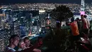 Gambar pada 14 Februari 2019 menunjukkan para turis mengambil gambar pemandangan cakrawala kota dari dek observasi Menara Kuala Lumpur di ibu kota Malaysia. Di sini pengunjung bisa mengamati segala penjuru kota Kuala Lumpur. (Mohd RASFAN / AFP)