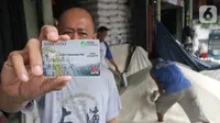 Pedagang menunjukkan Kartu Pedagang di Pasar Induk Beras Cipinang, Jakarta, Rabu (20/11/2019). Dengan Kartu Pedagang, para pedadang akan lebih mudah saat mengajukan kredit ke Bank DKI yang telah terekam dalam sebuah rekening keuangan. (Liputan6.com/HO/Budi)