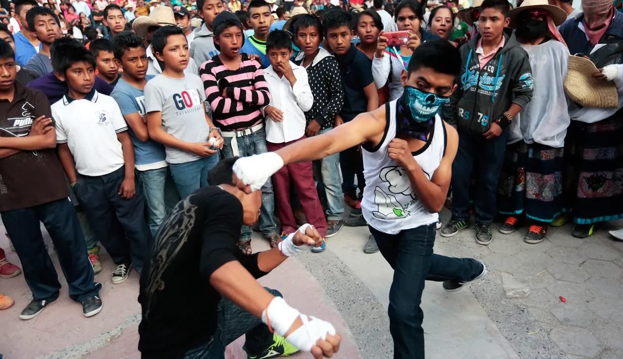 Ratusan anak melihat pertarungan dari Tradisi Xochimilcas di Zitlala, Guerrero, Meksiko (18/2). Tradisi ini merupakan simbol pembelaan terhadap kaum perempuan yang telah dilakukan selama bertahun-tahun. (AFP PHOTO/Pedro Pardo)