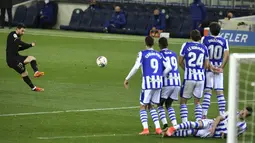 Penyerang Barcelona, Lionel Messi melakukan tendangan bebas saat melawan Real Sociedad pada pertandingan La Liga Spanyol di stadion Reale Arena, Spanyol (22/3/2021). Atas hasil ini, Lionel Messi dkk pun menggusur Real Madrid dari peringkat kedua klasemen. (AP Photo/Alvaro Barrientos)