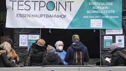 Orang-orang menunggu untuk melakukan tes covid-19 di pusat kota Essen, Jerman, Rabu (12/1/2022). Jerman melaporkan lebih dari 80.000 kasus virus corona dalam sehari yang merupakan tertinggi sejak pandemi pada Rabu. (AP Photo/Martin Meissner)