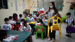 Seorang guru mengatur kursi sebelum dimulainya kelas di sebuah sekolah umum di Kota Quezon, Filipina pada Rabu (2/11/2022). Jutaan siswa kembali ke sekolah umum di seluruh Filipina saat pemerintah memberlakukan kembali pembelajaran di kelas secara tatap muka setelah lebih dari dua tahun lockdown akibat pandemi virus corona. (AP Photo/Aaron Favila)