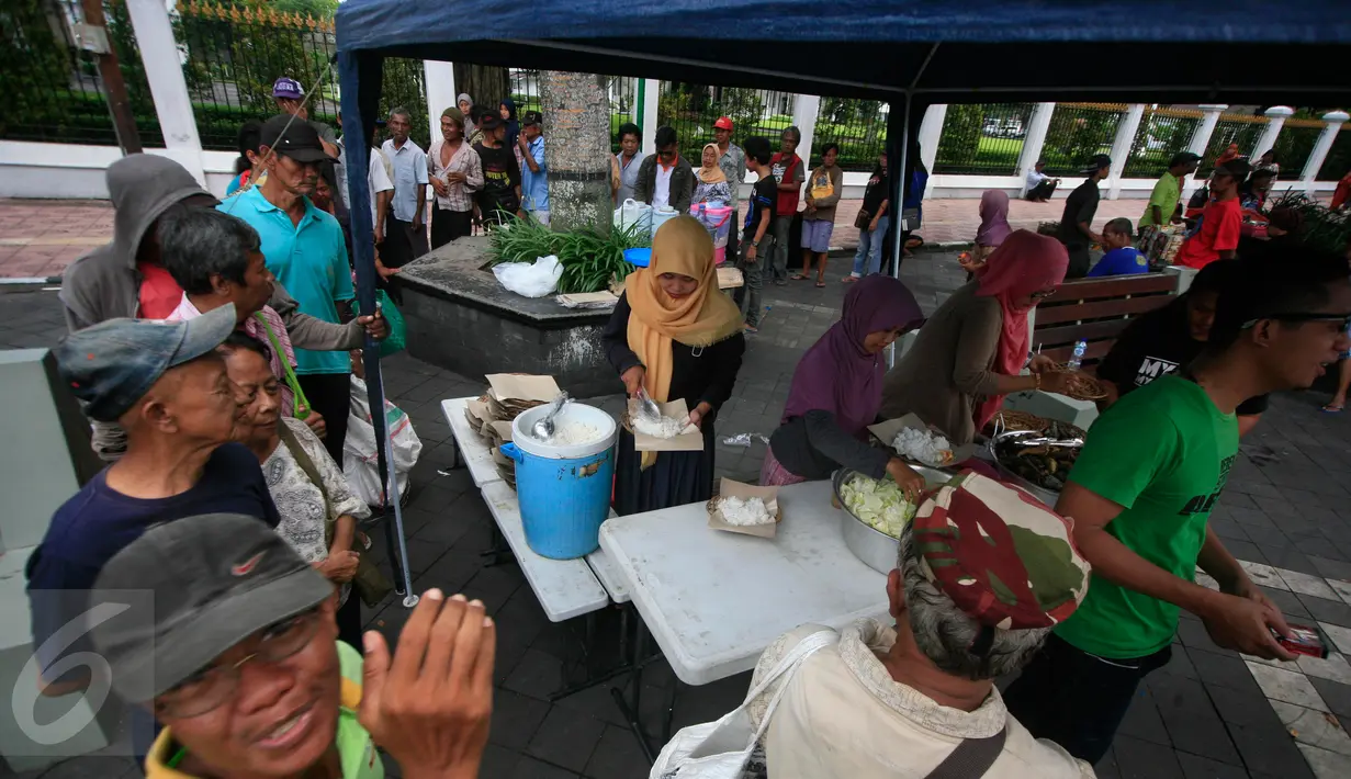 Sejumlah fakir miskin dan dhuafa mengantre untuk menikmati makanan gratis di warung tenda Shodaqoh, di kawasan titik nol Km Yogyakarta, Jumat (8/4). Warung ini hanya buka setiap hari Jumat pada pukul 11.00-13.00 WIB. (Foto: Boy Harjanto)