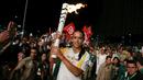 Supermodel Adriana Lima membawa obor pada malam penyambutan Olimpiade Rio 2016 di Maua Square Rio de Janeiro, Brasil, Kamis (4/8). (REUTERS / Pilar Olivares)