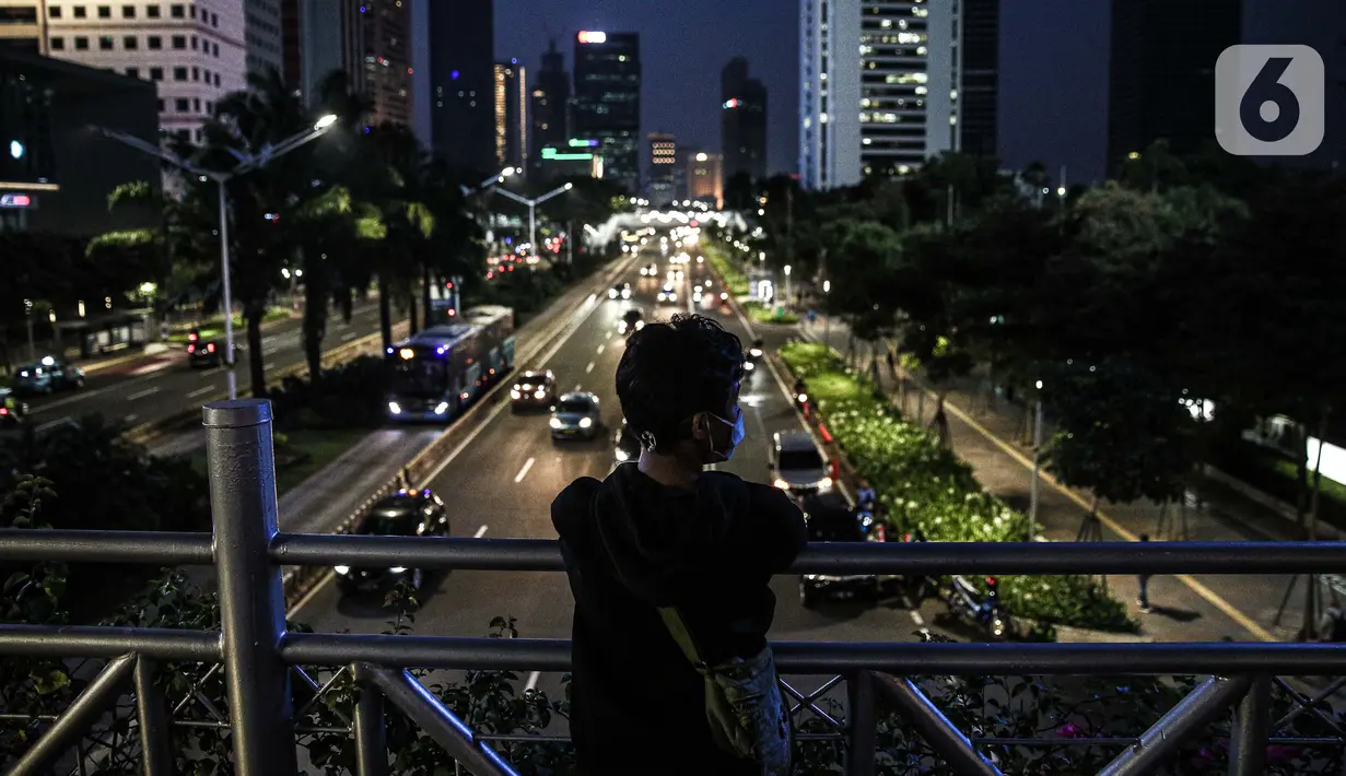 Warga berada di atas Jembatan Penyeberangan Orang (JPO) di Kawasan Sudirman, Jakarta, Kamis (24/9/2020). Pemprov DKI Jakarta kembali memperpanjang Pembatasan Sosial Berskala Besar (PSBB) hingga 11 Oktober untuk menekan laju penyebaran kasus covid-19. (Liputan6.com/Faizal Fanani)