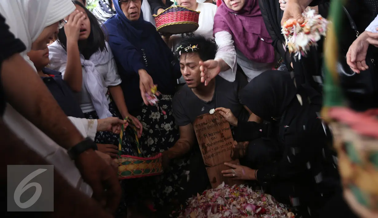 Keluarga dan kerabat menaburkan bunga di atas pusara almarhum ayah Ariel NOAH, Nazmul Irphan bin Muhammad Saleh, Bandung, Selasa (29/3/2016). Almarhum dimakamkan di TPU Nagrog di kawasan Ujung Berung (Liputan6.com/Herman Zakharia)