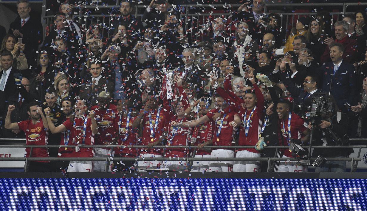 Para pemain Manchester United merayakan keberhasilan meraih gelar Piala Liga usai mengalahkan Southampton. Piala Liga merupakan gelar kedua MU musim ini setelah sebelumnya mereka meraih gelar Community Shield. (AFP/Glyn Kirk)