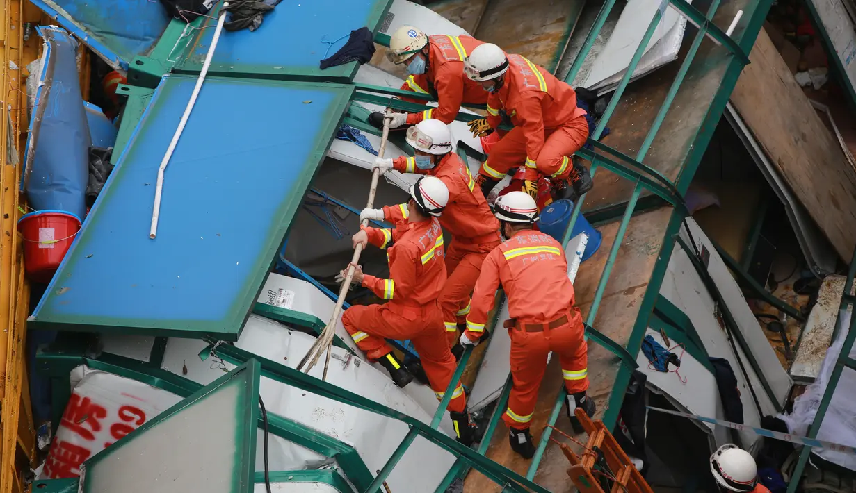 Sejumlah tim SAR menyisir lokasi runtuhnya sebuah crane besar yang menimpa bangunan sementara dua lantai di Kota Dongguang, Guangdong, Tiongkok, Rabu (13/46). Crane tersebut runtuh akibat badai yang menerjang kota Dongguan. (AFP/CHINA OUT)