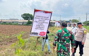 Pihak aparat gabungan mencopot spanduk sebagai upaya meredam saling klaimnya dua desa di Pati. (Foto: Liputan6.com/Arief pramono).