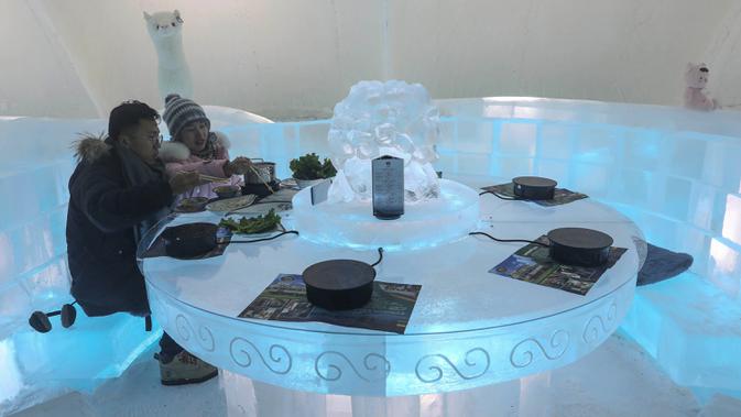 Foto yang diambil 13 Januari 2020 menunjukkan orang-orang menikmati hot pot di meja dan kursi berukir es di dalam igloo selama Festival Es dan Salju Internasional Harbin tahunan. Sementara hampir seluruh perabot di dalam restoran ini seperti meja dan kursi, terbuat dari es. (STR/AFP)