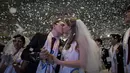 Pasangan berciuman seusai pernikahan massal yang diselenggarakan oleh Gereja Unifikasi di Gapyeong, Korea Selatan, Selasa (3/2/2015). Ratusan pasangan menikah di markas Gereja Unifikasi Korsel. (AFP PHOTO/Ed Jones) 