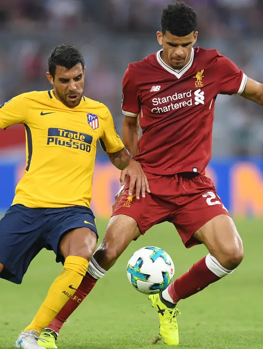 Bek Liverpool Dominic Solanke berebut bola dengan pemain Atletico Madrid, Augusto pada final Audy Cup di Munchen, (2/8). Atletico menang 5-4 atas Liverpool lewat adu penalti setelah bermain imbang 1-1. (AFP Photo/Christof Stache)