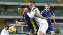 Pemain Juventus, Federico Bernardeschi, berebut bola dengan pemain Hellas Verona, Kevin Lasagna, pada laga Liga Italia di Stadion Marc'Antonio Bentegodi, Minggu (28/2/2021). Kedua tim bermain imbang 1-1. (Paola Garbuio/LaPresse via AP)