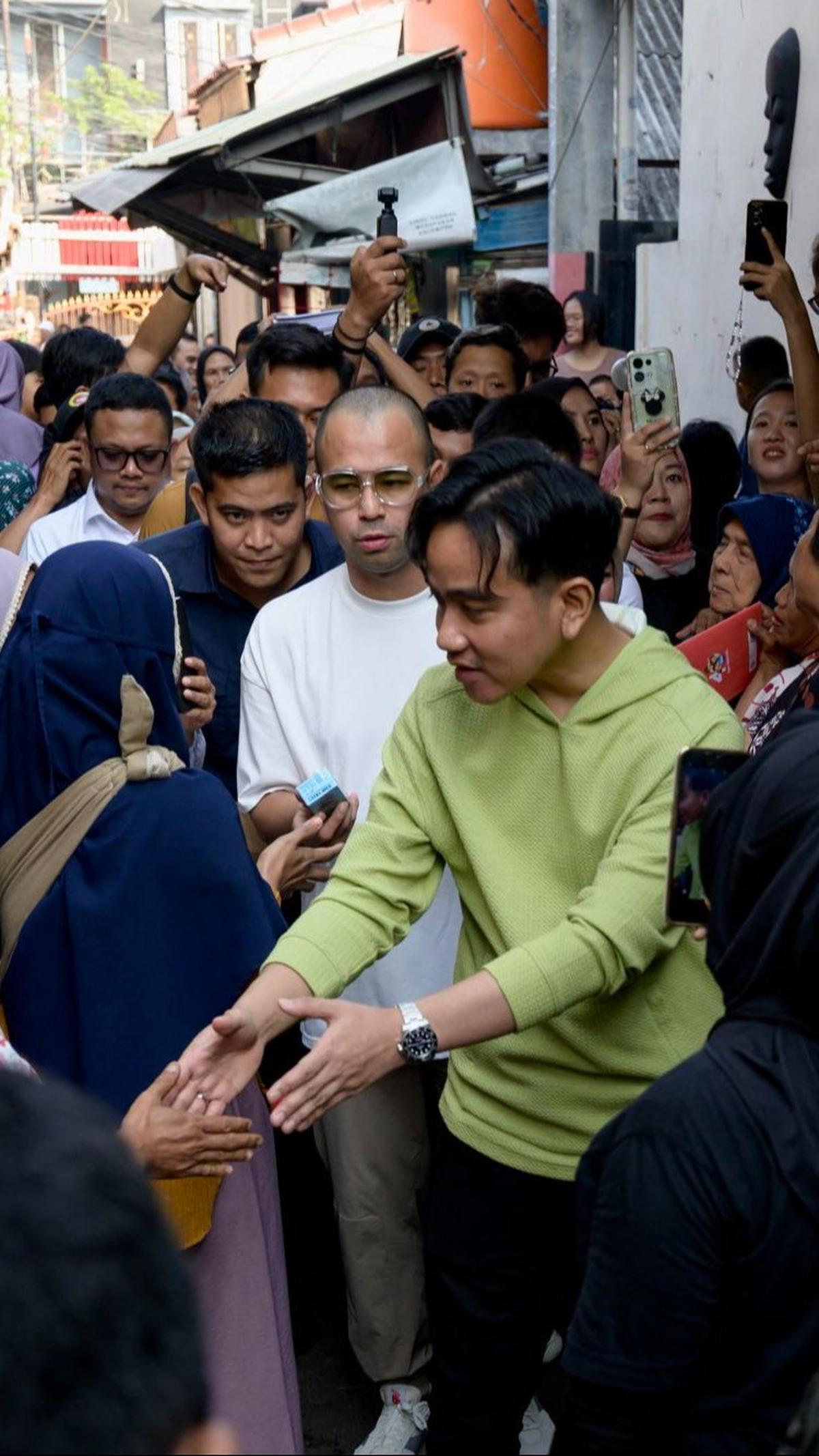 Gibran tampak didampingi artis Raffi Ahmad dalam aksi blusukannya kali ini.&nbsp;Foto: Bay Ismoyo/AFP