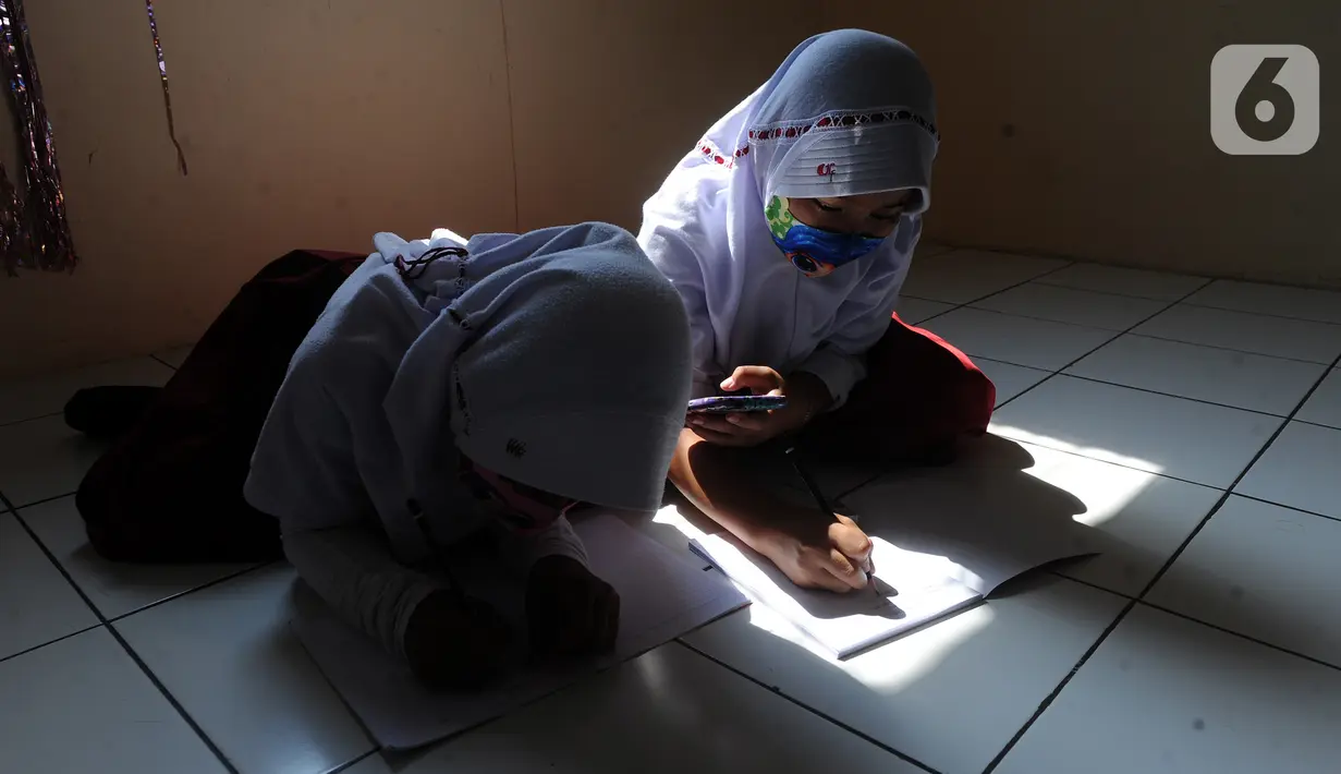 Murid-murid SD belajar dengan memanfaatkan wifi gratis di Balai RW kawasan Tegal Gundil, Bogor, Jawa Barat, Senin (21/9/2020). Pemkot Bogor menyebar lebih dari 50 titik wifi publik gratis untuk menunjang Pembelajaran Jarak Jauh (PJJ) siswa di Kota Bogor. (merdeka.com/Arie Basuki)