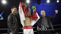 Daud Yordan (tengah)  merayakan kemenangan usai memukul KO lawannya Campee Phayom dari Thailand di OCBC Arena, Singapura, Sabtu (25/3/2017).  (Bola.com/Nicklas Hanoatubun)
