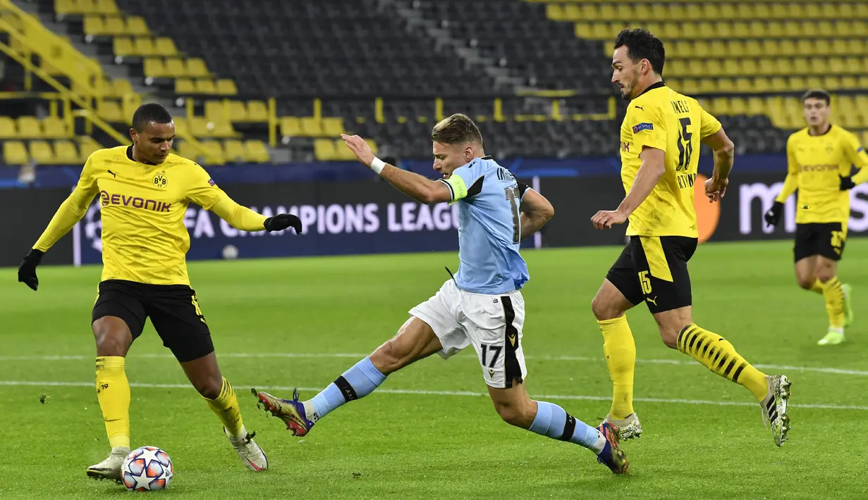 Penyerang Lazio, Ciro Immobile mencoba melepaskan tembakan di depan pemain Borussia Dortmund, Manuel Akanji dan Mats Hummels pada matchday kelima Grup F Liga Champions di Signal Iduna Park, Kamis (3/12/2020) dinihari WIB. Borussia Dortmund imbang 1-1 dengan Lazio. (AP Photo/Martin Meissner, Pool)