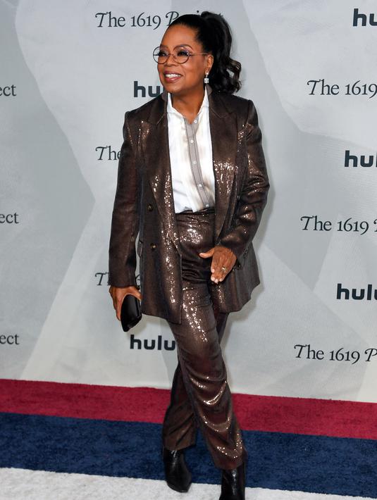 <p>Oprah Winfrey menghadiri pemutaran perdana The 1619 Project di Academy Museum of Motion Pictures, Los Angeles, California, Amerika Serikat, 26 Januari 2023. Winfrey mengenakan mantel dan celana cokelat mengkilap. (VALERIE MACON/AFP)</p>