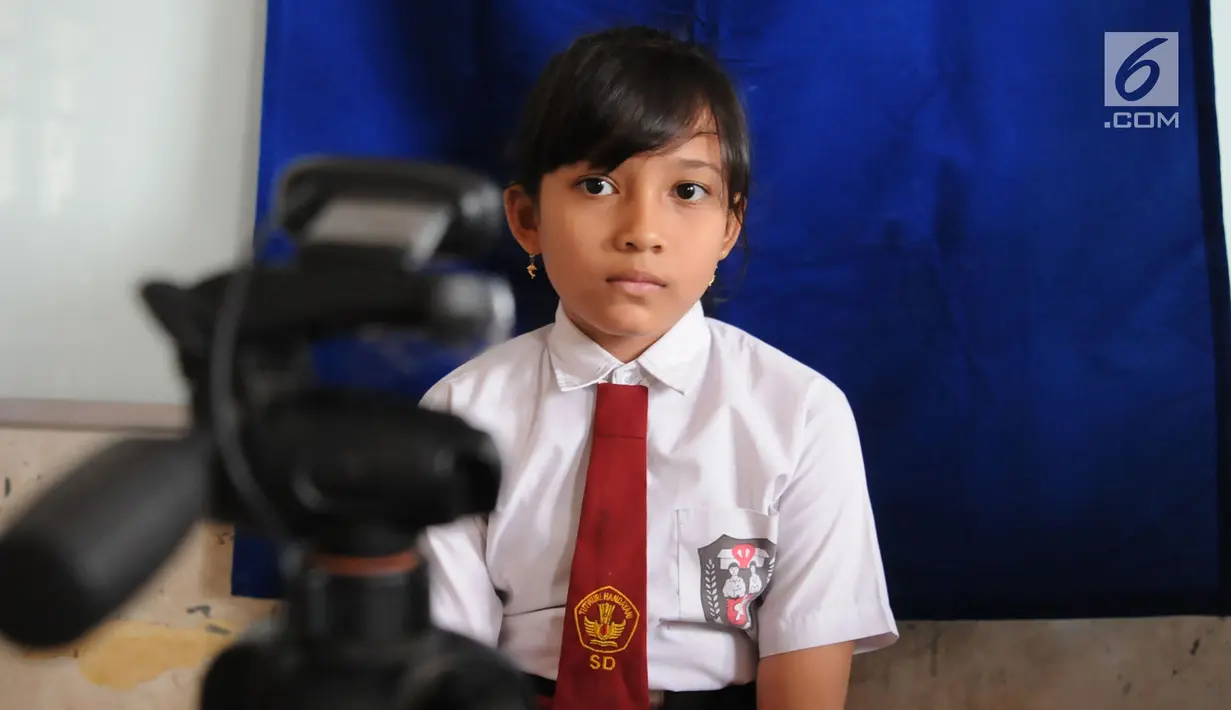 Seorang siswa bersiap untuk difoto saat membuat Kartu Identitas Anak (KIA) di SD Negeri 01 Sawah Baru, Ciputat, Jumat (27/4). KIA ini bermanfaat sebagai bentuk pemenuhan hak anak dan dokumen kependudukan. (Merdeka.com/Arie Basuki)