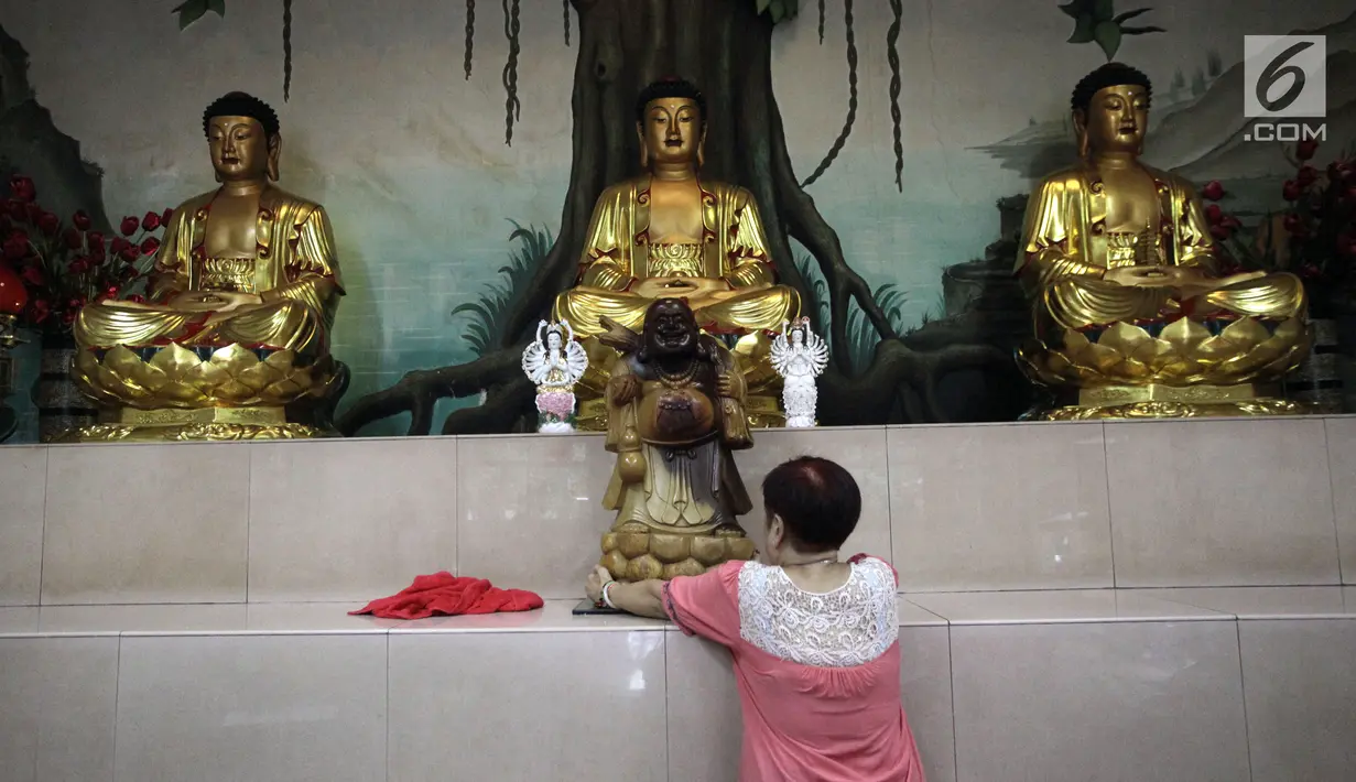 Seorang  warga merapikan letak patung di Vihara Amurva Bhumi, Jakarta, Kamis (8/2). Tahun Baru Imlek 2569 jatuh pada 16 Februari 2018. (Liputan6.com/Arya Manggala)