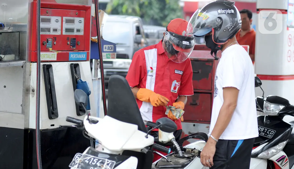 Petugas dengan sarung tangan, masker dan pelindung wajah melayani pembeli BBM di SPBU kawasan Cilendek, Bogor, Selasa (5/5/2020). Mencegah penularan Covid-19, sejumlah perusahaan memberikan pelindung diri kepada pegawai, terlebih yang berhubungan langsung dengan pelanggan. (merdeka.com/Arie Basuki)