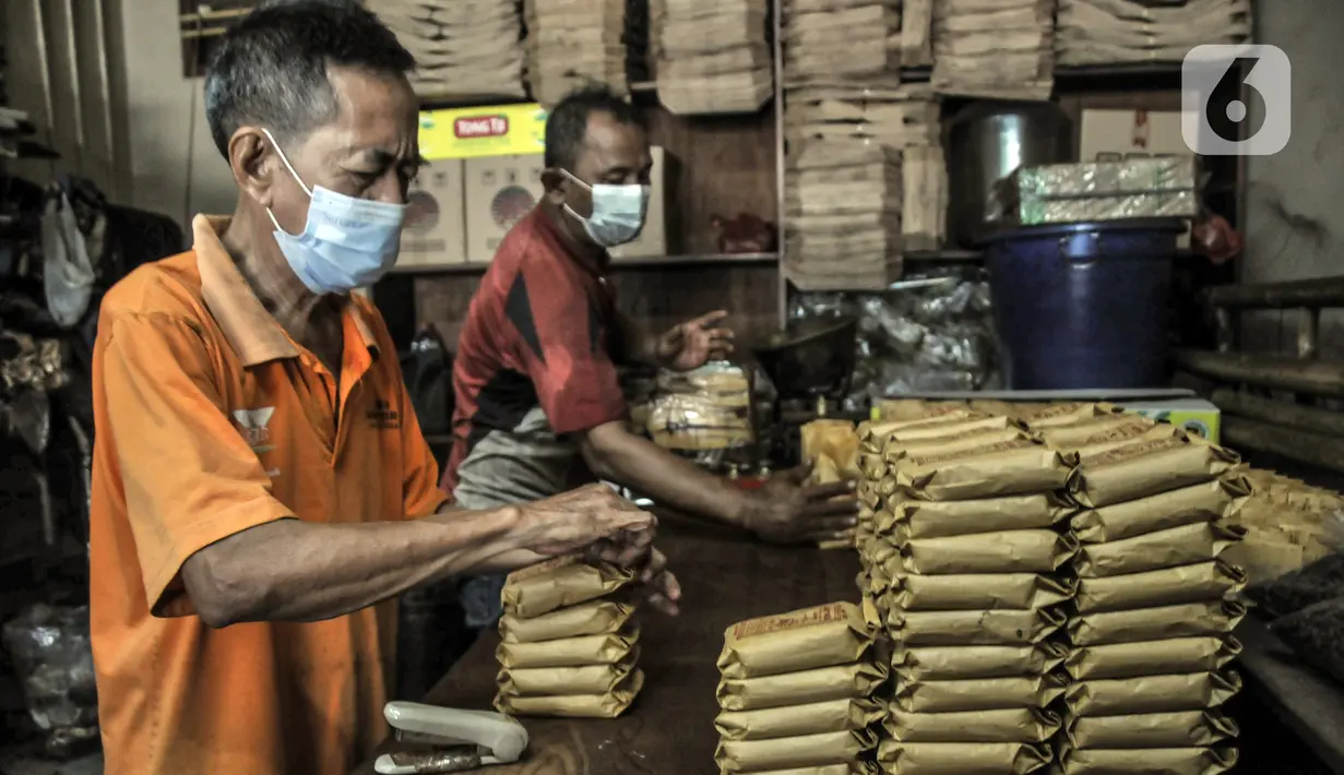 Pekerja mengemas kopi yang telah digiling ke dalam kemasan di toko kopi Sari Murni, Jatinegara, Jakarta Timur, Selasa (4/1/2021). Untuk kopi jenis robusta dijual kisaran Rp 60 ribu-Rp 75 ribu per kilogram. (merdeka.com/Iqbal S. Nugroho)