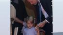 Pangeran William membujuk putranya, Pangeran George untuk turun dari pesawat sesampainya di bandara Tegel, Berlin, Rabu (19/7). Ikut dalam tur keluarga kerajaan Inggris, George kelihatan lelah dan mengantuk saat turun pesawat. (Kay Nietfeld/POOL/AFP)