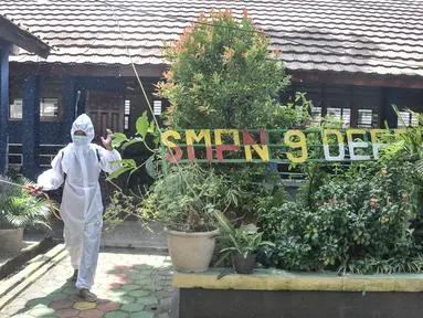 Petugas sekolah menyemprotkan disinfektan usai Pembelajaran Tatap Muka (PTM) 100 persen di SMP Negeri 9 Depok, Cipayung, Jawa Barat, Senin (24/1/2022). Pihak sekolah melakukan penyemprotan disinfektan secara rutin seiring dimulainya pelaksanaan PTM 100 persen di Depok. (merdeka.com/Iqbal S Nugroho)