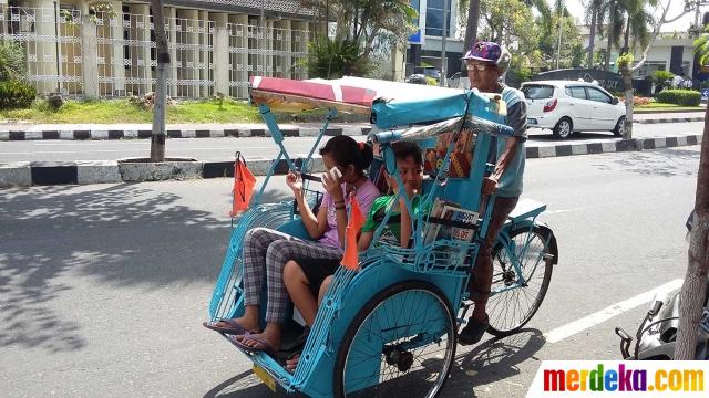 Penumpang becak pak Sutopo bisa membaca buku gratis di perjalanan | Copyright merdeka.com/purnomo edi