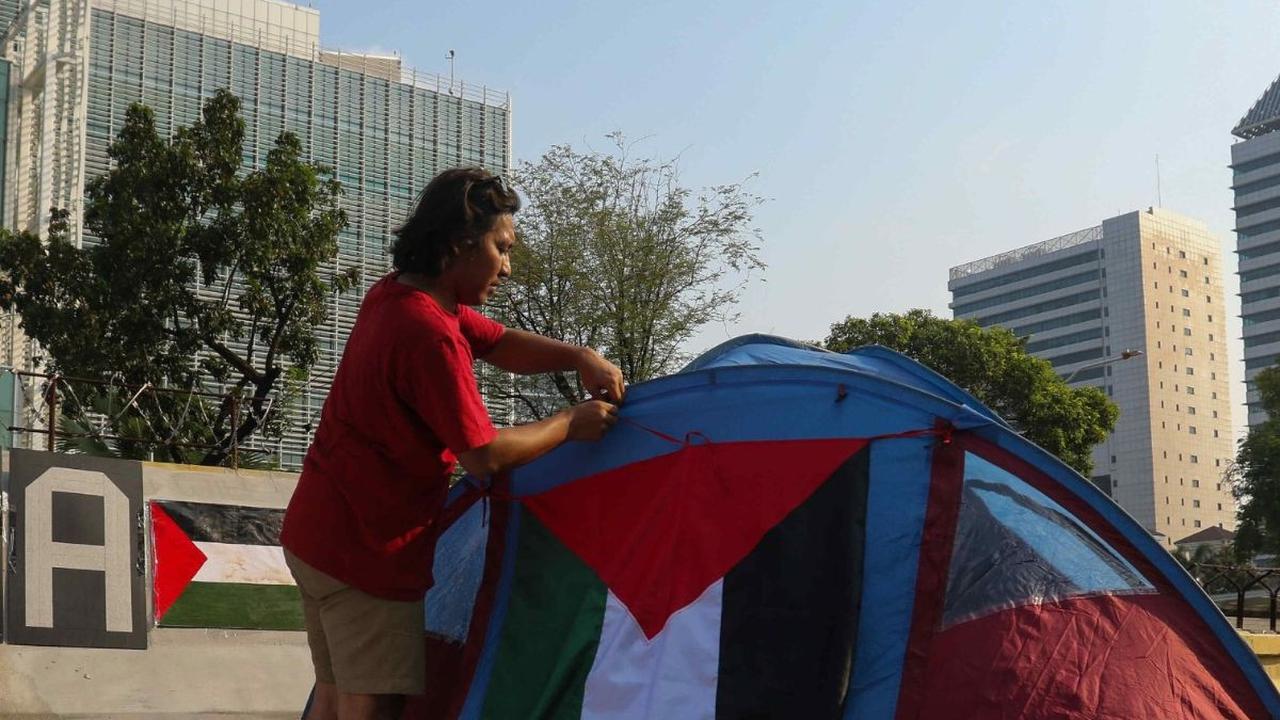 Seorang pengunjuk rasa yang tergabung dalam Koalisi Musisi untuk Gaza memasang bendera Palestina pada tenda yang didirikan di depan Kedutaan Besar Amerika Serikat (AS), Jakarta, Jumat (10/5/2024). Menyusul gerakan mahasiswa di sejumlah kampus di Amerika S
